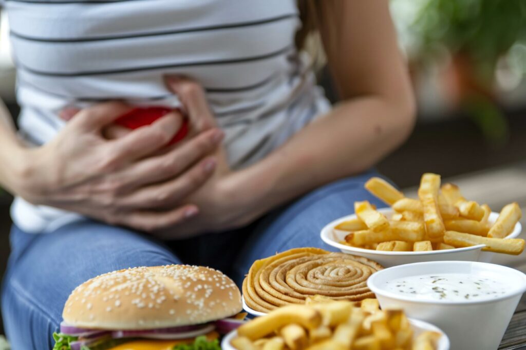 After Consuming Unhealthy Fast Food, Person Suffers from Stomach Heartburn